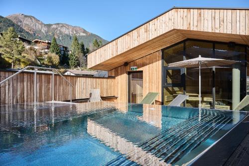 een huis met een zwembad voor een gebouw bij Lärchenlodge SkySpa and Rooftop Pool inklusive Stubai SuperCard in Fulpmes