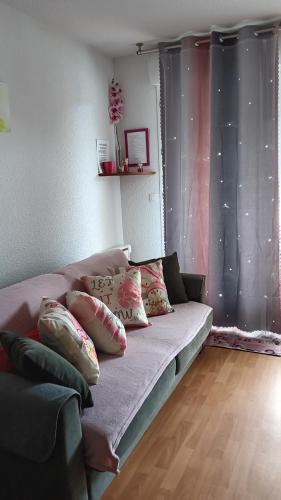 a couch in a living room with pillows on it at 31 avenue GEORGES CLEMENCEAU in Le Mont-Dore