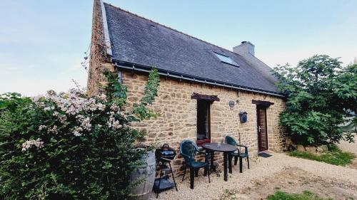 ein Gebäude mit Stühlen und einem Tisch davor in der Unterkunft Gîte CosyCool in Languidic