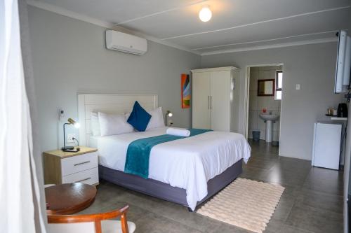 een slaapkamer met een groot wit bed met blauwe kussens bij 5@Partridge Guesthouse in Newcastle