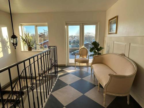 a living room with two chairs and a staircase at Vrensted Hostel B&B in Løkken