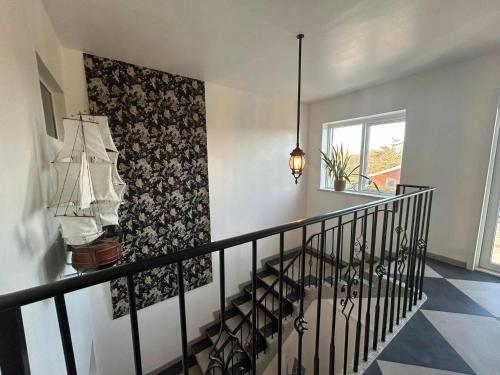 a stairway with a black railing and a wall at Vrensted Hostel B&B in Løkken