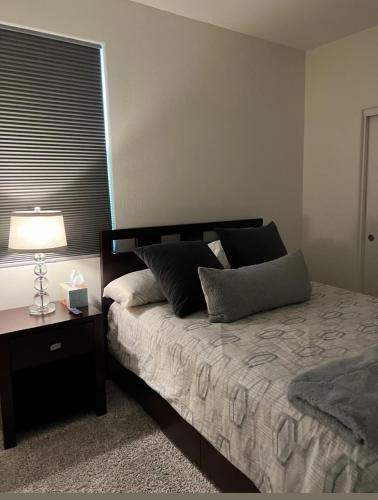 a bedroom with a bed with a lamp and a window at Downtown Private room in Abu Dhabi