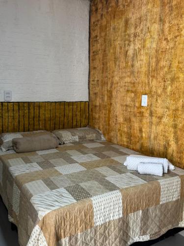 a bedroom with a large bed with a wooden wall at Cabanas Carijó in Santarém
