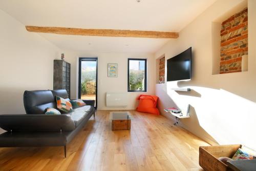 een woonkamer met een bank en een tv bij NEW - Maison brique 4p - Côte Pavée coeur Toulouse in Toulouse