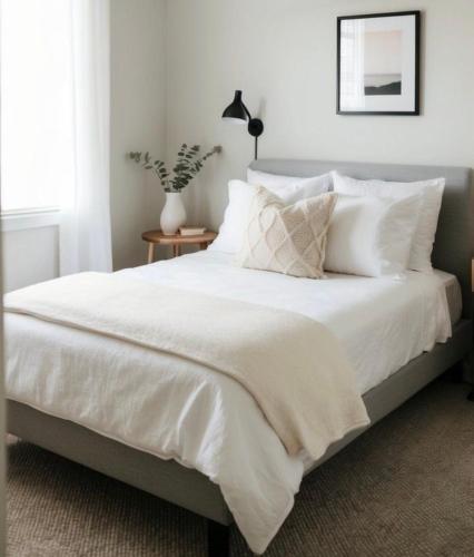 a bedroom with a bed with white sheets and pillows at Downtown Private room in Abu Dhabi