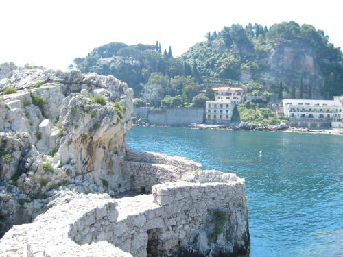 a view of a body of water with a rocky shore at Taormina Bay Lucia's House Roccalumera in Roccalumera
