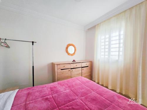 ein Schlafzimmer mit einem rosa Bett und einem Fenster in der Unterkunft Entire condo hosted by Dar Al Khayma in Agadir