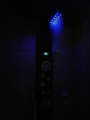 een donkere kamer met een klok en blauwe lampen bij Cabalove in Quissac