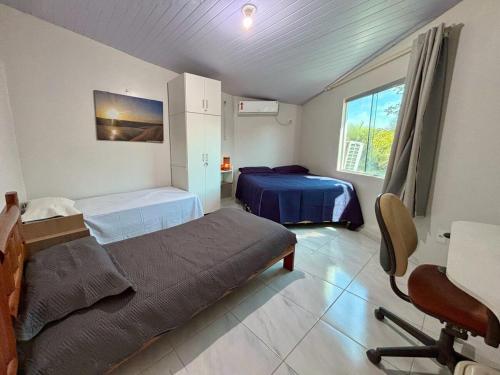 una camera con 2 letti, una scrivania e una sedia di Apto com 2 Suítes em condomínio beira-rio a Barreirinhas