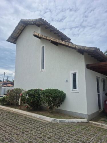 a white house with two bushes in front of it at Buzios Inn in Búzios