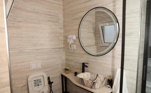 een badkamer met een wastafel en een spiegel bij Kremelo Hotel in Berat