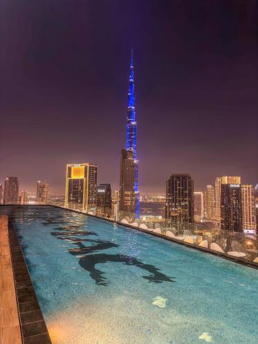 a swimming pool with a city skyline at night at 2BR Burj Khalifa and Sea View Apartments in Paramount Hotel Midtown in Dubai