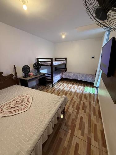 ein Zimmer mit zwei Betten und einem Flachbildfernseher in der Unterkunft Refugio Paradisíaco 4 in Piçarras