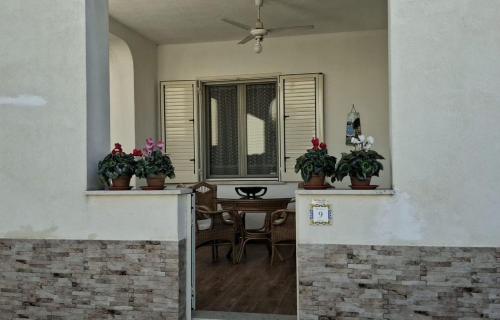 ein Wohnzimmer mit Topfpflanzen und einem Tisch in der Unterkunft Villa Rosaria Triscina di Selinunte in Triscina