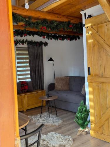 un soggiorno con divano e albero di Natale di EscapeTinyCabin by IezerVenture a Lereşti