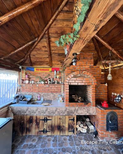 una cocina con chimenea de ladrillo en una casa en EscapeTinyCabin by IezerVenture, en Lereşti