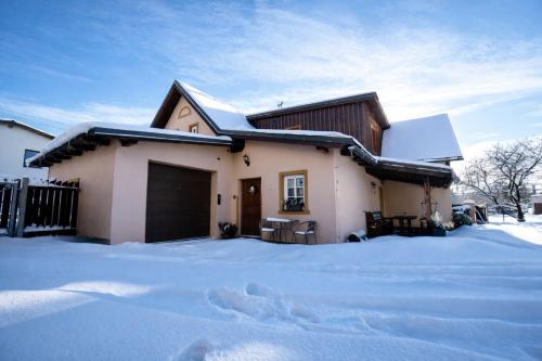 a house covered in snow with a driveway at Krkonošská chaloupka in Černý Dŭl