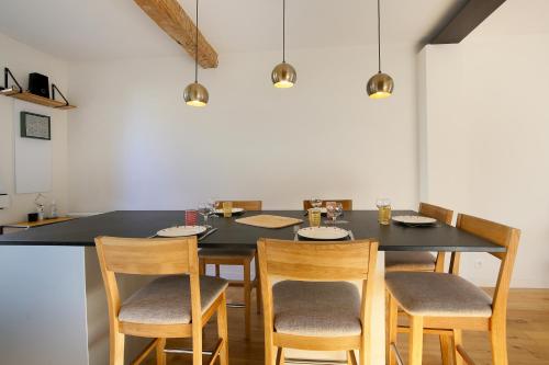 een eettafel met stoelen en een zwarte tafel bij NEW - Maison brique 4p - Côte Pavée coeur Toulouse in Toulouse