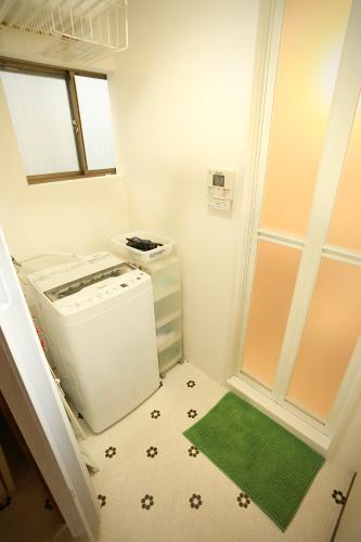 a small kitchen with a refrigerator and a green rug at Japanese Cozy House Near Nagoya Station in Nagoya