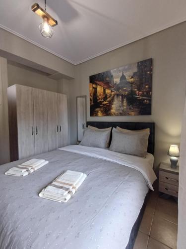 een slaapkamer met een groot wit bed met een schilderij aan de muur bij SeaSide FirView Studio in Néa Khilí