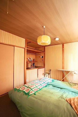 a large green bed in a room with a ceiling at Japanese Cozy House Near Nagoya Station in Nagoya