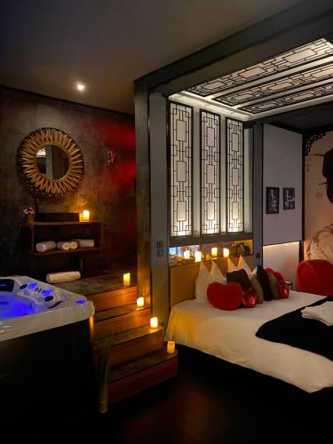 une chambre avec un lit, un miroir et une table dans l'établissement Suite 5 étoiles 50 nuances plus zen avec Jacuzzi et jeu pour adulte, à Lagrâce-Dieu