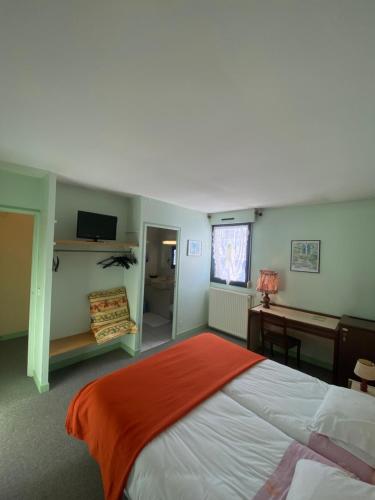 une chambre avec un grand lit et un bureau dans l'établissement Le Grand Connétable, à Châteauneuf-de-Randon