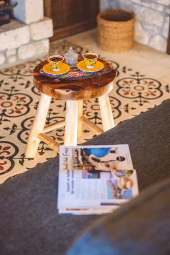 a small wooden table with two cups of tea on it at Cumbali Konak Hotel (Adults Only +12) in Alaçatı