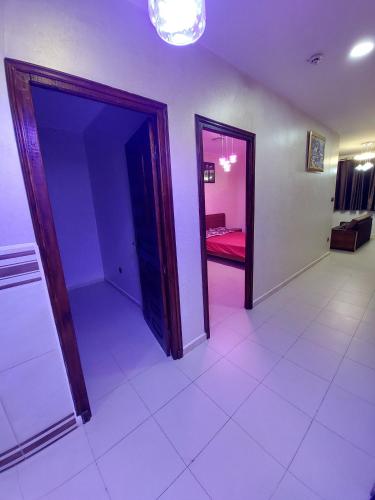 een kamer met twee deuren en een kamer met een rode bank bij اقامة الجنينة in Kouba