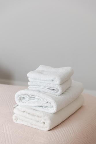 a stack of white towels sitting on a bed at D&E Cozy Stay in Sauk