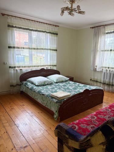a bedroom with a bed in a room with windows at Karpatski Prostory in Slavske
