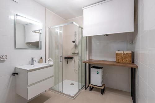 een witte badkamer met douche en wastafel bij Sleep & Cozy Disneyland in Coupvray