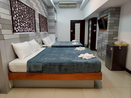 Een bed of bedden in een kamer bij Hi End Hotel Sriracha