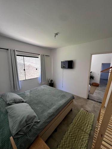 una camera da letto con un letto grande e una finestra di Apartamentos e Suites Casa Verde a Búzios