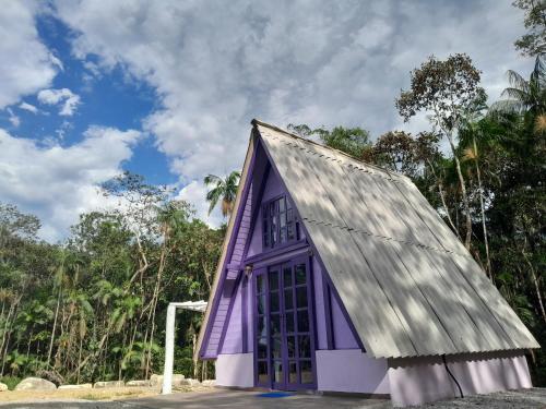 ein lila Gebäude mit grauem Dach in der Unterkunft Refúgio dos Valdenses in Morretes