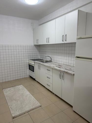 una cucina vuota con mobili ed elettrodomestici bianchi di 01 Apartment a Kosovo Polje