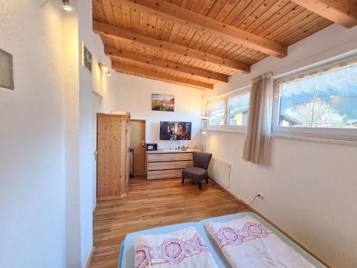 a bedroom with two beds and a desk and a window at am Mühlbach - Ferienwohnungen Luttinger in Bichlbach