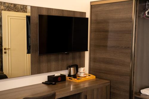 een kamer met een tv aan een muur met een tafel bij Wan Hotel in Duhok