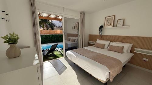 a bedroom with a bed and a view of a pool at Palmview Private Pool in Arguineguín