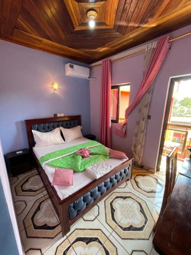 een slaapkamer met een bed in een kamer bij NGK Hôtel Apartment in Bafoussam