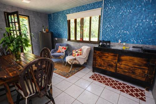 una stanza con tavolo, sedie e parete blu di Casa da Índia - Pousada Jussara a Joinville