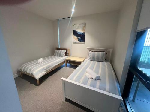 una camera da letto con due letti e una finestra di Boxhill home a Box Hill