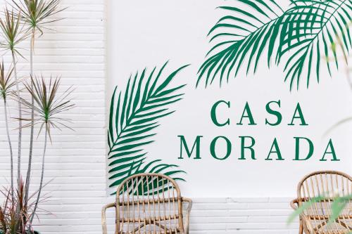 a sign that reads casa mandera on a wall with two chairs at Casa Morada in Islamorada
