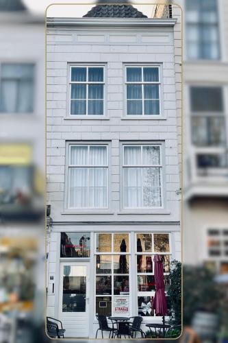 a white building with a table and chairs in front of it at La Focaccina B&B in Dordrecht