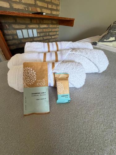 een stapel handdoeken en een doos op een bed bij Kairos Beach Hotel in Camocim