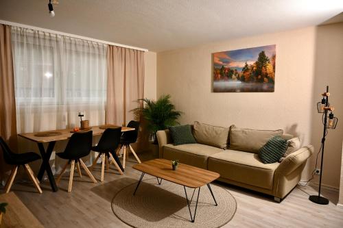 een woonkamer met een bank en een tafel bij Black Forest Retreat in Niederdorla