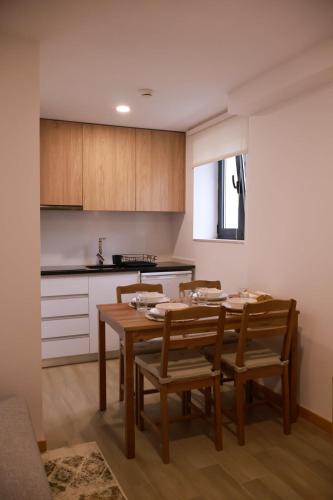 a kitchen with a table and chairs in a room at VIELA Guest House T2 in Barcelos