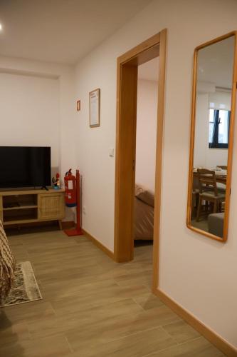 a living room with a television and a mirror at VIELA Guest House T2 in Barcelos