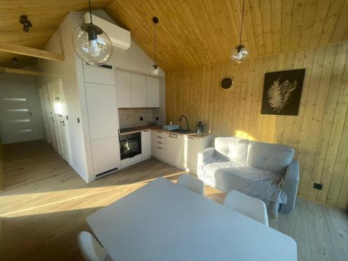 een keuken en woonkamer met een witte tafel en stoelen bij Pochyła 80 home&spa in Rybnik
